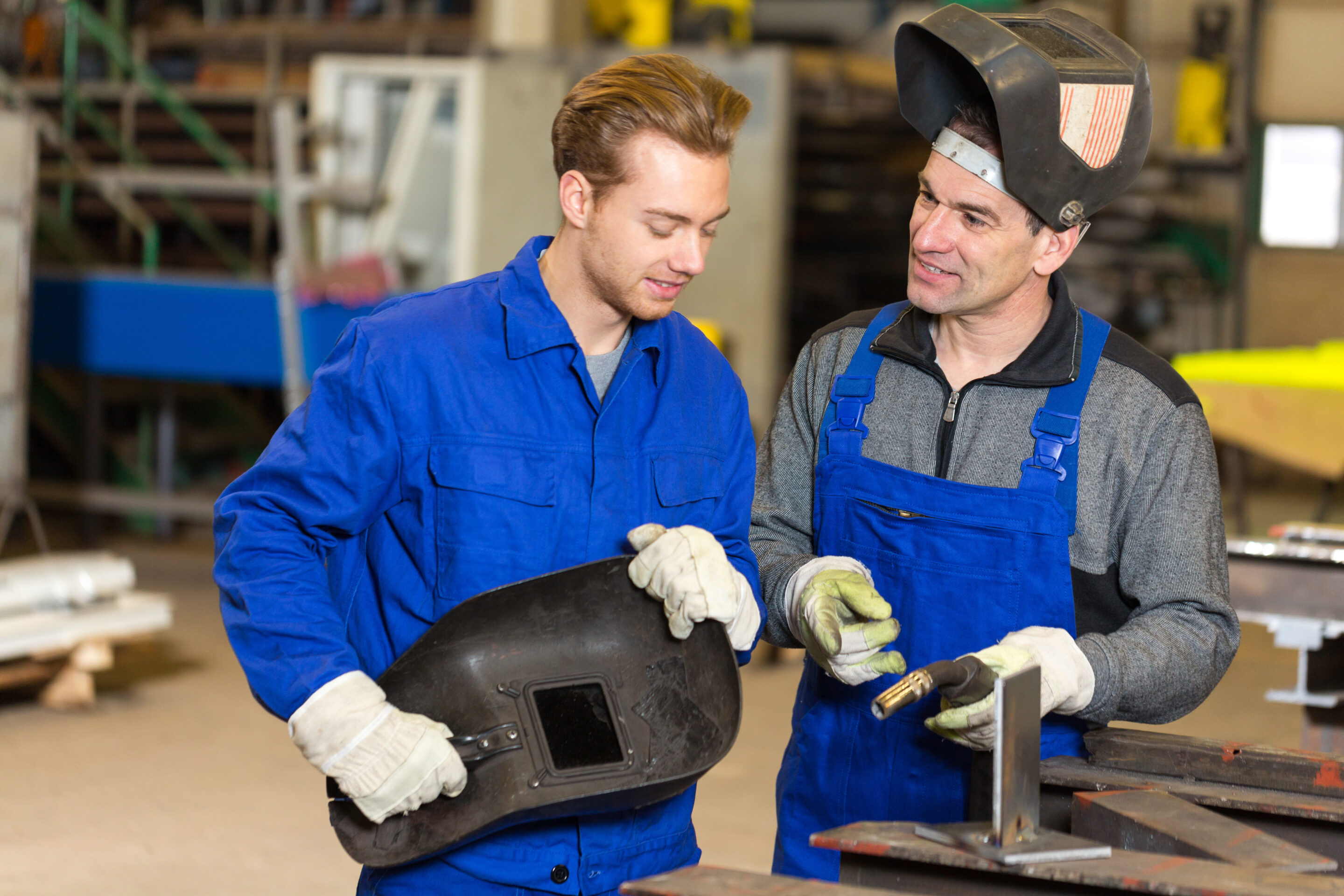 Ausbilder und Auszubildender beim Schweißen von Metall
